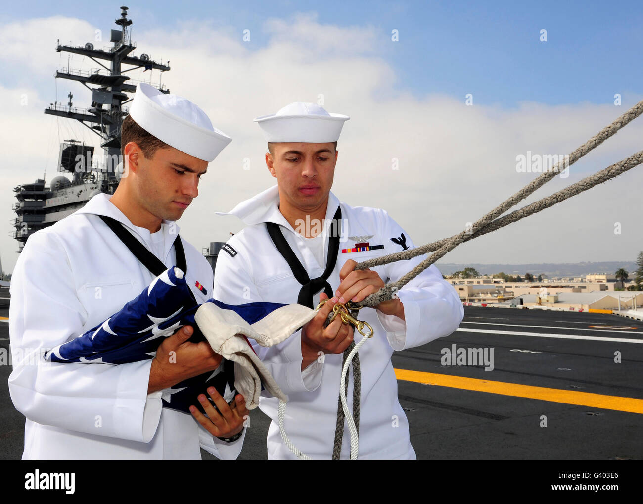 Matrosen vorzubereiten, die amerikanische Flagge auf dem Flugdeck der USS Ronald Reagan zu erhöhen. Stockfoto