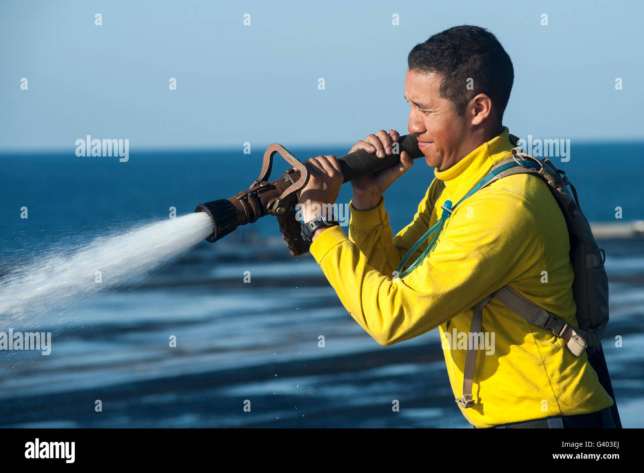 Luftfahrt Boatswain Mate sprüht Wasser um das Flugdeck der USS Harry S. Truman zu reinigen. Stockfoto