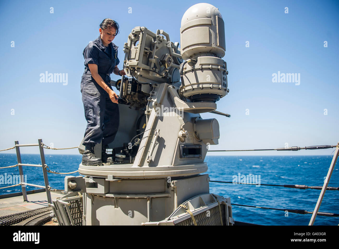 Seaman führt Wartungsarbeiten an einer Mark 38 MOD 2 25mm Maschinengewehr / Stockfoto