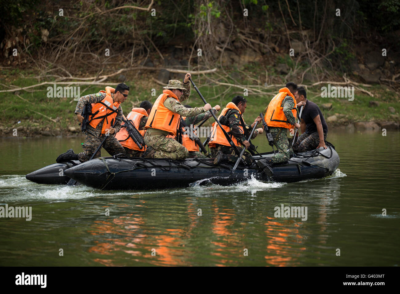 Philippinische und US special Operations Forces Soldaten einen Fluss paddeln. Stockfoto