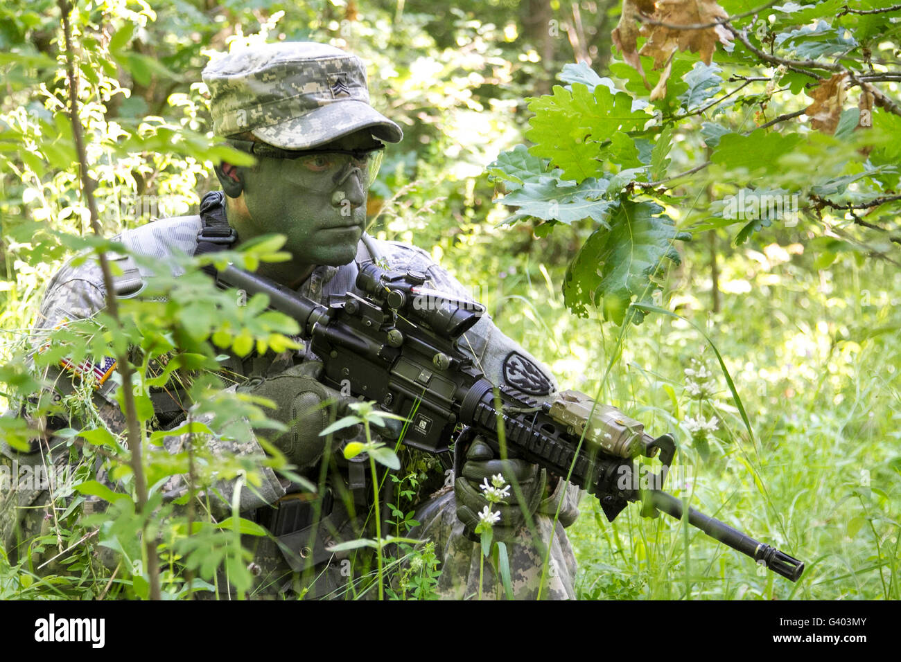 Ein Soldat trägt Gesicht malen harmonisch in die umliegende Vegetation. Stockfoto