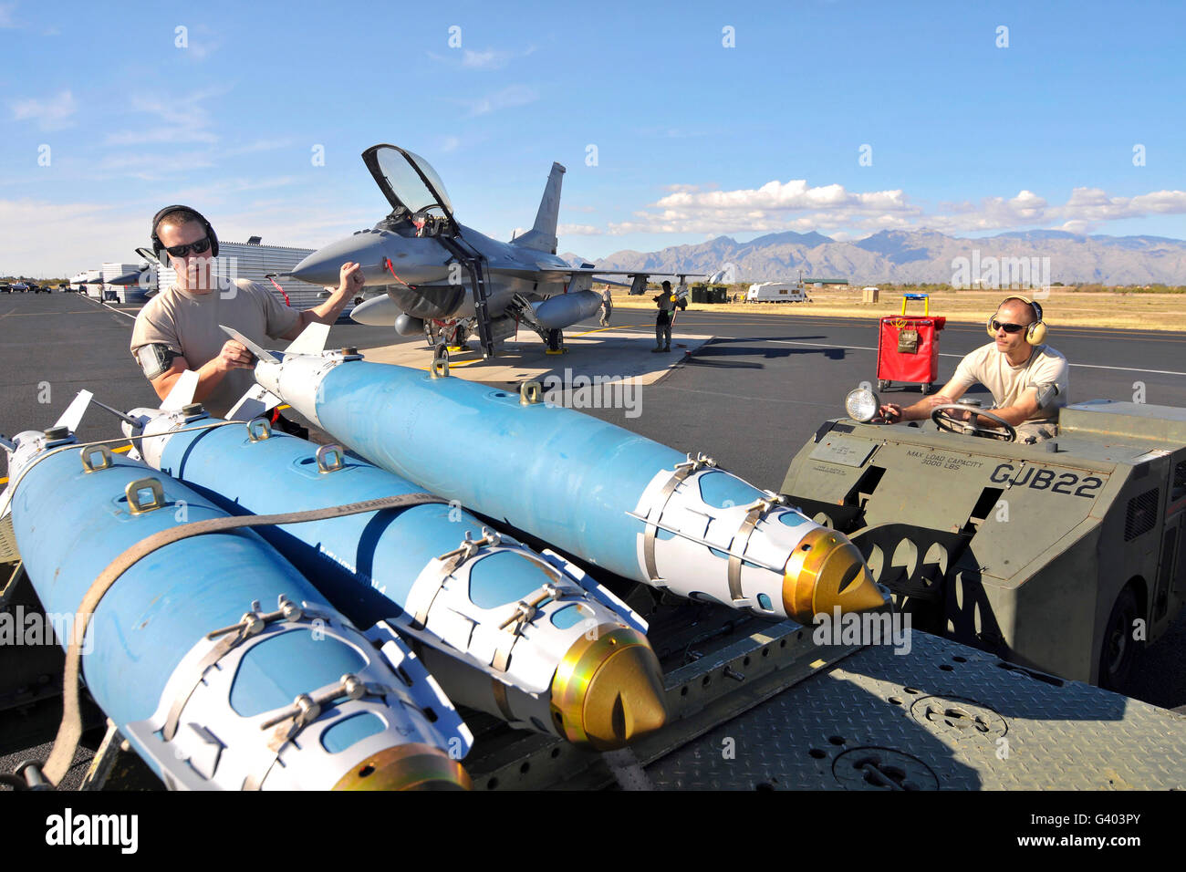 US Air Force Piloten laden eine GBU-38 auf einen Waffen-Transport-Anhänger. Stockfoto