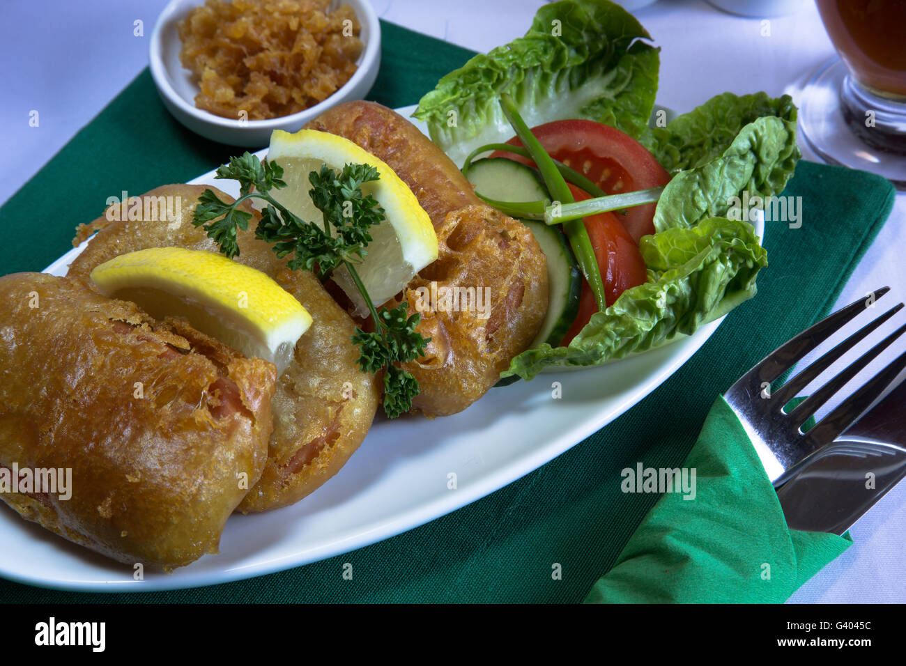 Ein klassisches englisches Gericht von Spam Krapfen serviert mit Beilagensalat und Grieben, genommen in Durham, England. Stockfoto