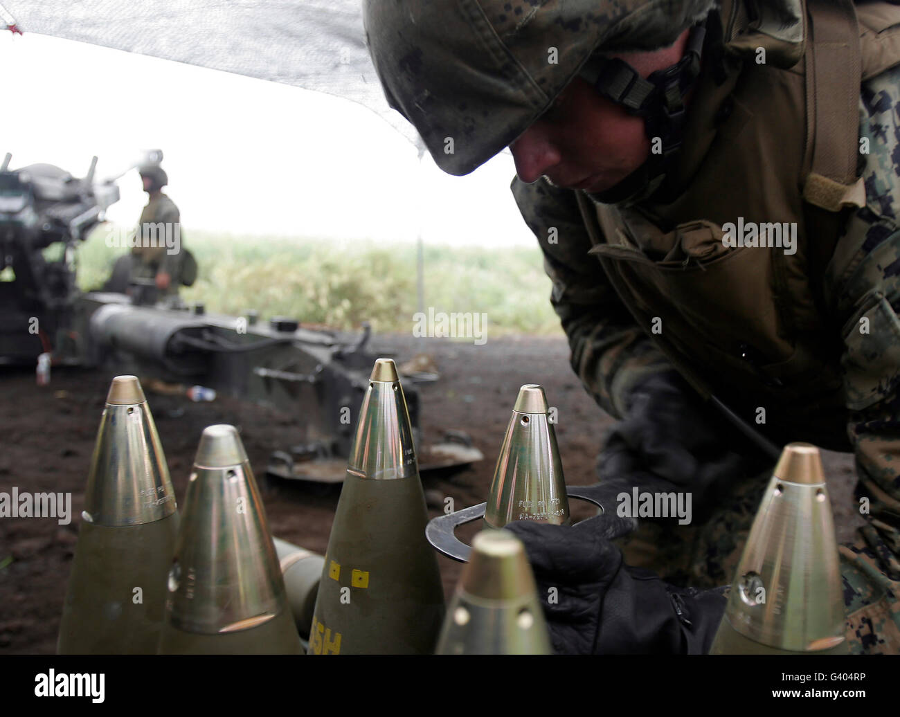 Soldat strafft Sicherungen, Artillerie-Granaten für ein M-198 mittlere Haubitze 155 mm. Stockfoto