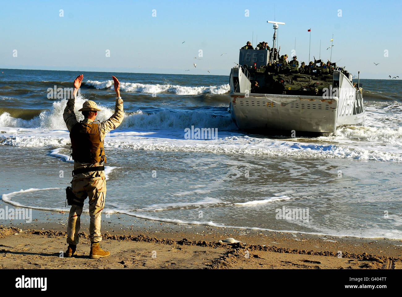 Ein Strand-Meister signalisiert ein Landungsboot von Onslow Beach. Stockfoto