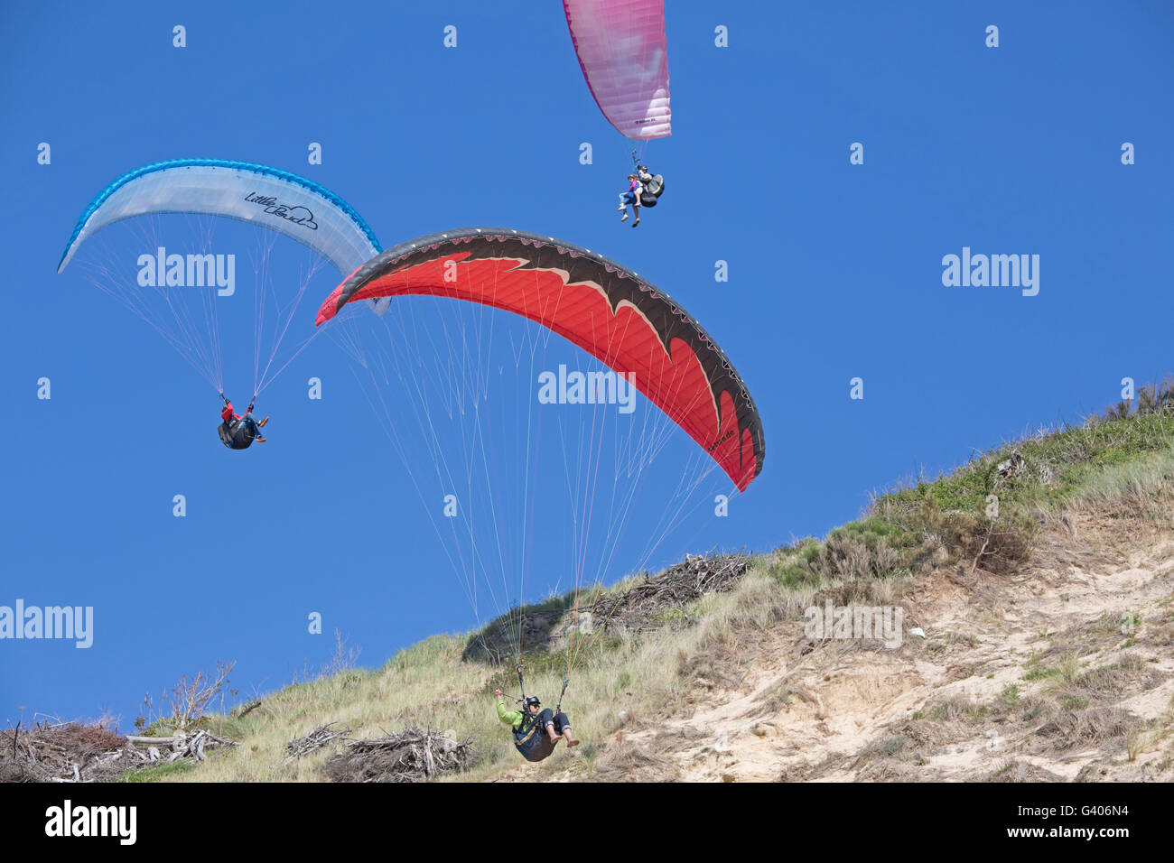 Drei Gleitschirme fliegen über Sand Düne von Pyla Südfrankreich Stockfoto