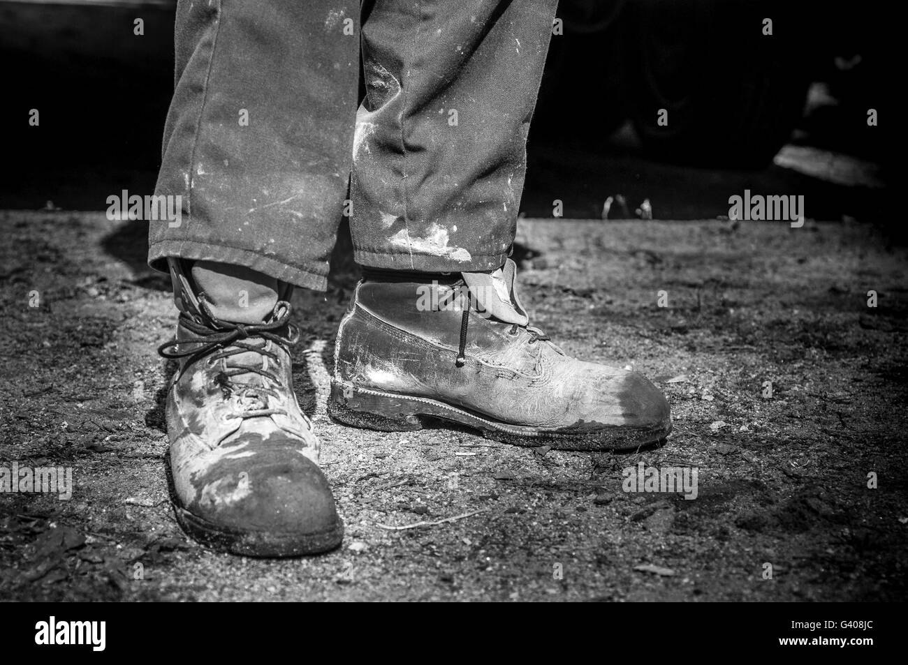 Nahaufnahme von alt und schmutzig Zement Arbeiter Stiefel in schwarz / weiß Stockfoto