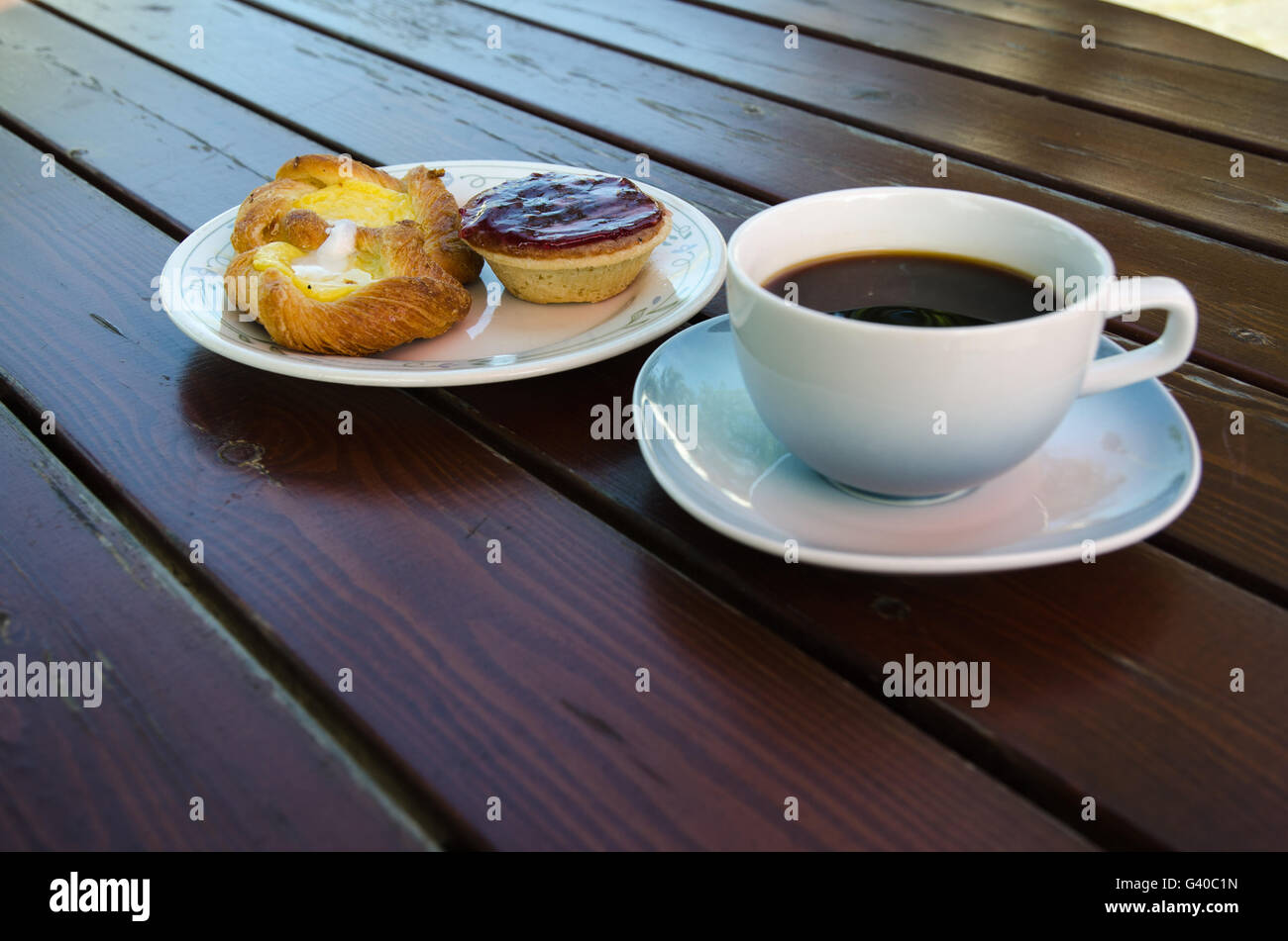Eine Tasse Kaffee mit Gebäck auf einem Holztisch rurstic Stockfoto