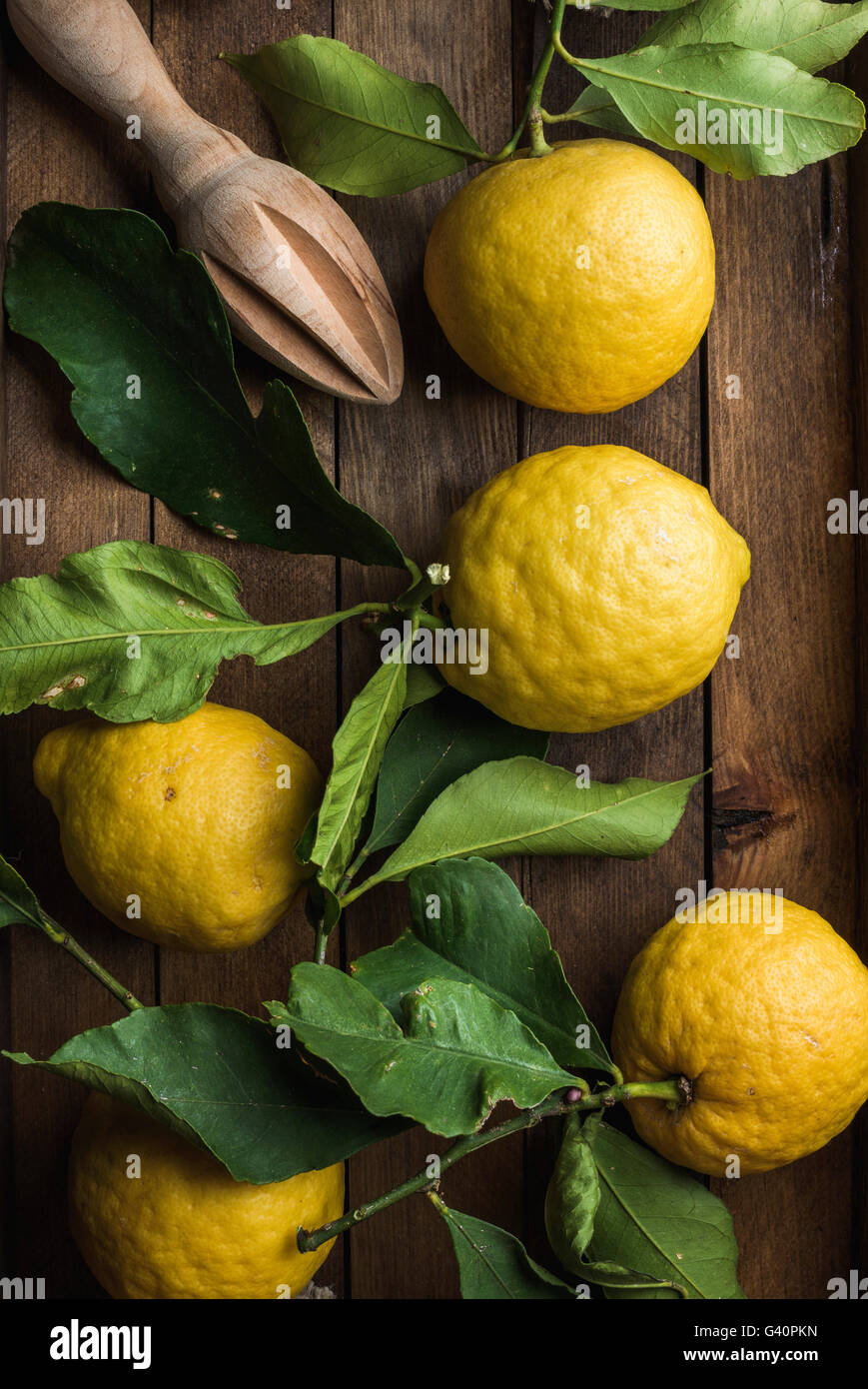 Frische Zitronen mit Blättern in rustikalen Holzkiste. Ansicht von oben Stockfoto