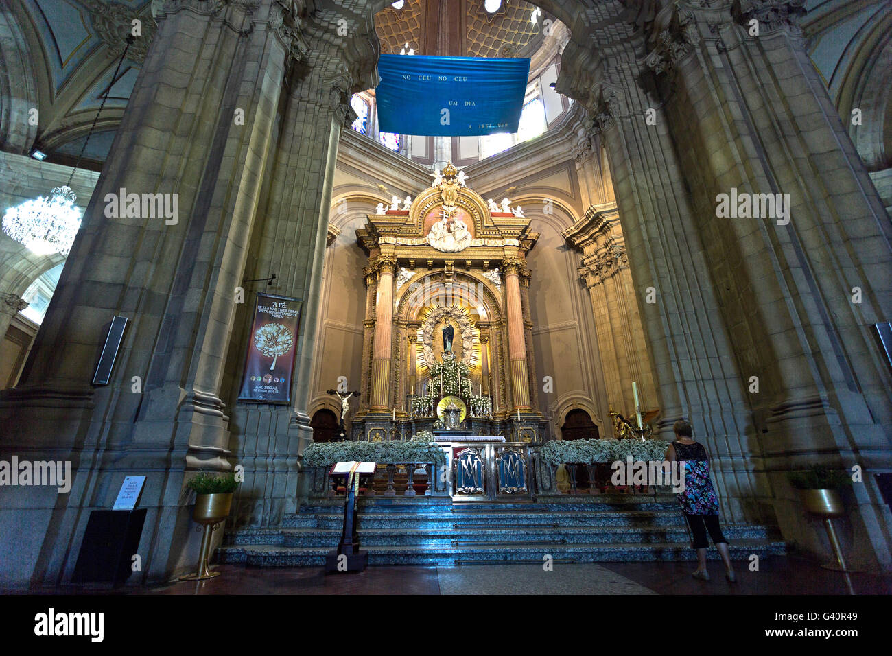 Der Hauptaltar und eine Person, die Ehrfurcht und Verehrung für die Muttergottes in der Wallfahrtskirche von Sameiro in Braga, Portugal Stockfoto
