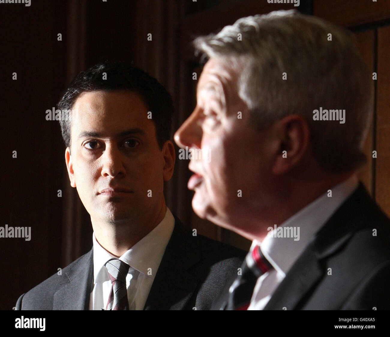 Der Vorsitzende der Labour Party, Ed Miliband (links), hört zu, wie der Schattenkanzler Alan Johnson auf einer Pressekonferenz im Church House in Westminster, im Zentrum von London, spricht. Herr Miliband fordert die Regierung auf, die Steuer auf die Boni der Banker, die im vergangenen Jahr 3.5 Milliarden erhöht haben, zu verlängern. Stockfoto