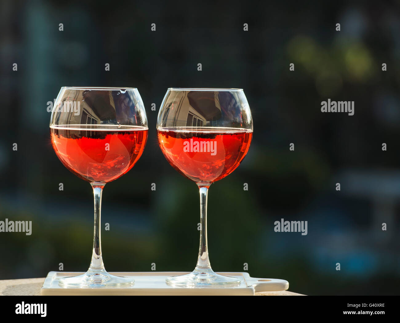 Zwei Gläser rose Wein, dunkles Grün Hintergrund Stockfoto