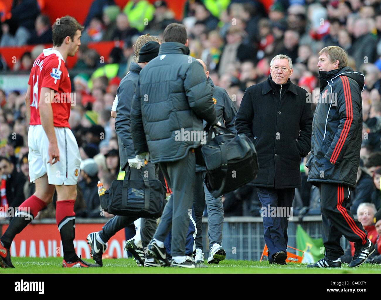 Manchester United Manager Alex Ferguson (zweite rechts) Und Liverpool-Manager Kenny Dalglish (ganz rechts) Auf der Touchline zusammen als Manchester United Michael Carrick (Ganz links) Geht nach der Bestrahlung auf zur Touchline Das Spielfeld Stockfoto