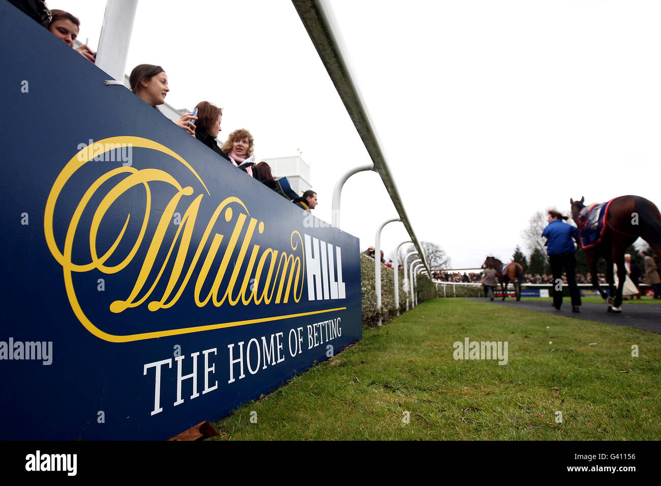 Pferderennen - William Hill Super Saturday - Kempton Park. Racegoers neben dem Paradering im Kempton Park Stockfoto