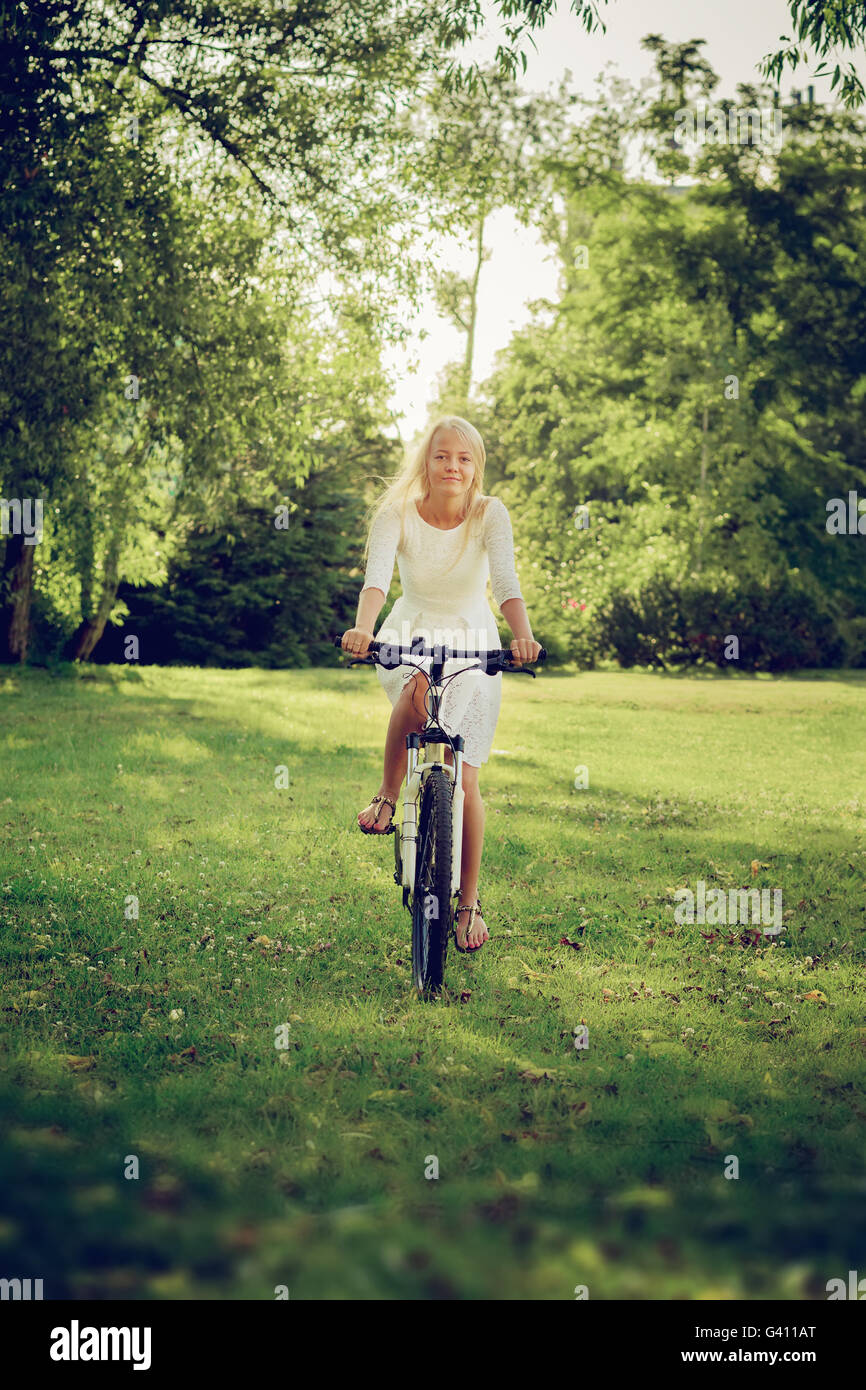 Blondes Mädchen Radfahren am sonnigen Wiese, getönten Bild Stockfoto