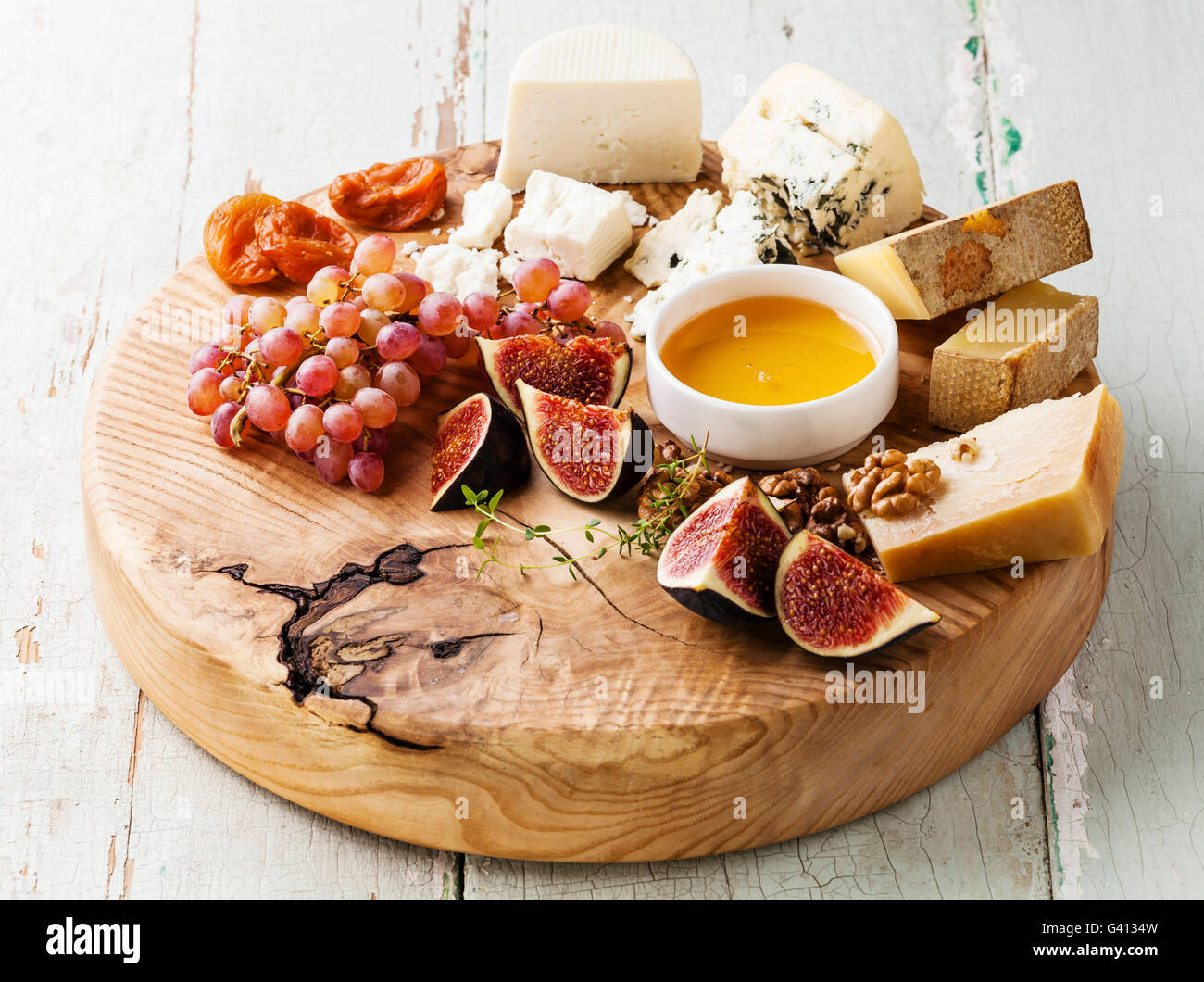 Käse-Platte-Snacks-Sortiment mit Honig auf Holzbrett Stockfoto