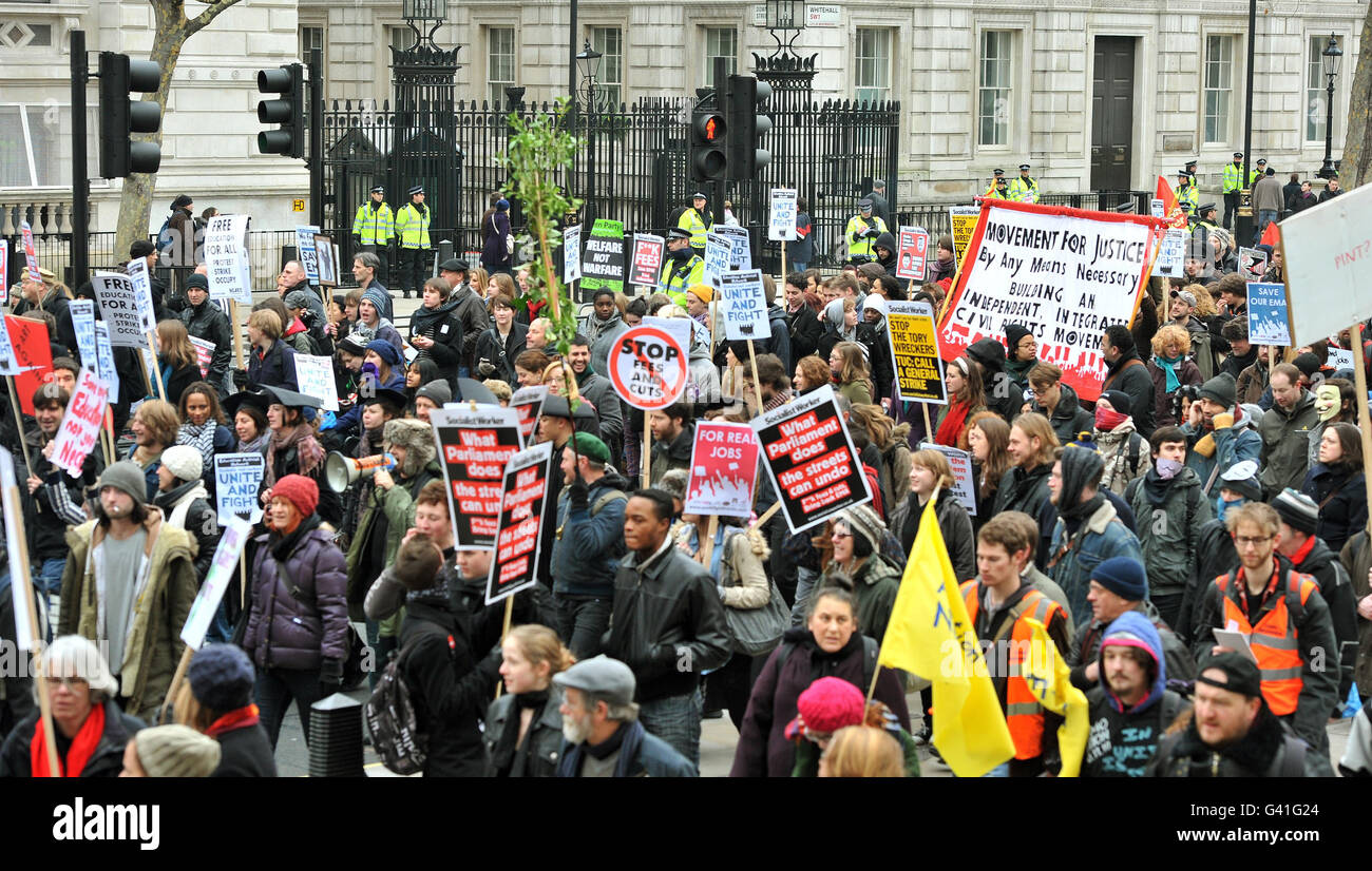 Eine Gruppe von Studenten geht an der Vorderseite der Downing Street (Tore im Hintergrund) vorbei, vor einer Demo gegen Bildungskürzungen der Regierung, bevor sie an den Houses of Parliament im Zentrum von Westminster, London, vorbeigeht. Stockfoto