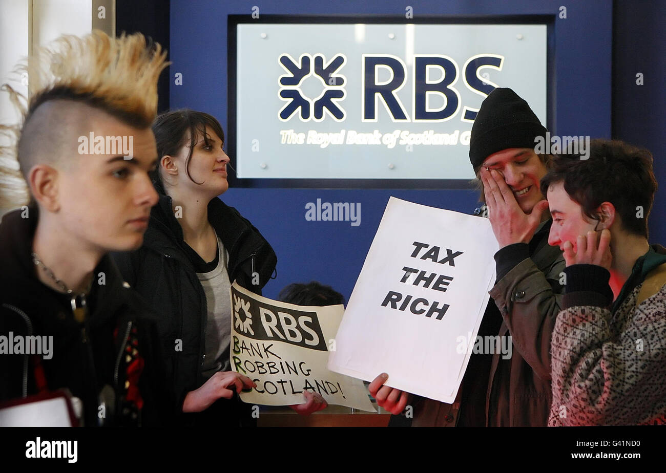 Mitglieder der Protestgruppe Citizens Vereinigten sich gegen Kürzungen bei öffentlichen Dienstleistungen, während eines Protestes, der die Regulierung von Banken und die Abschaffung von Boni forderte, in einem Gebäude der Royal Bank of Scotland in Glasgow, Schottland. Stockfoto