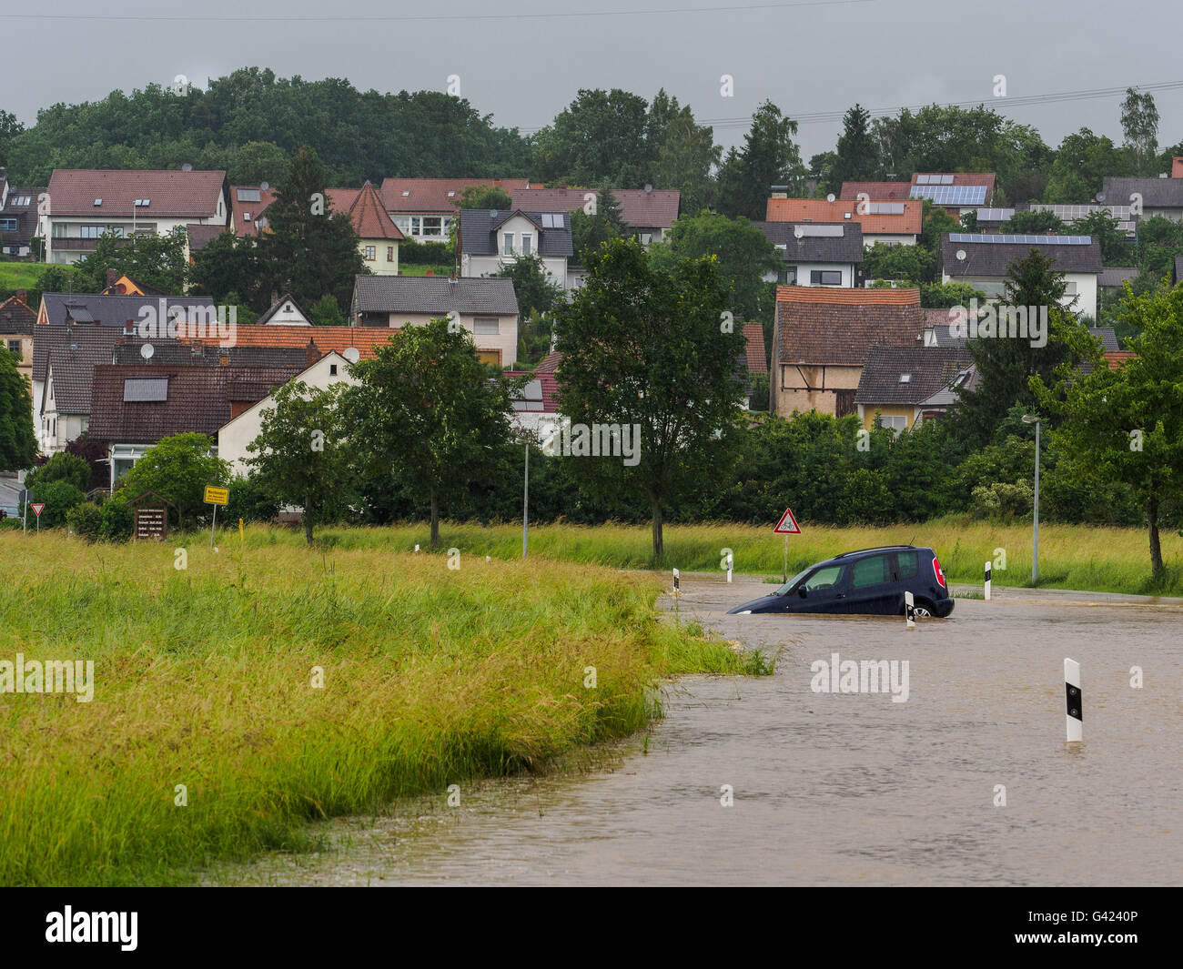 Memmelsdorf, Deutschland. 17. Juni 2016. Ein Auto ist auf einer überfluteten Landstraße in der Nähe von Memmelsdorf, Deutschland, 17. Juni 2016 stecken. Foto: NICOLAS ARMER/Dpa/Alamy Live News Stockfoto
