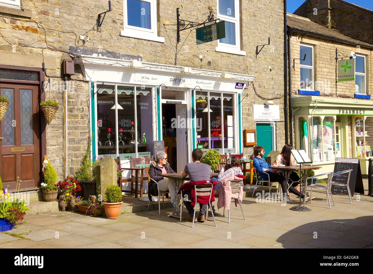 Menschen außerhalb Cafe sitzen. Cafe1618, 16 Marktplatz, Middleton-in-Teesdale, County Durham, England, Vereinigtes Königreich, Europa. Stockfoto