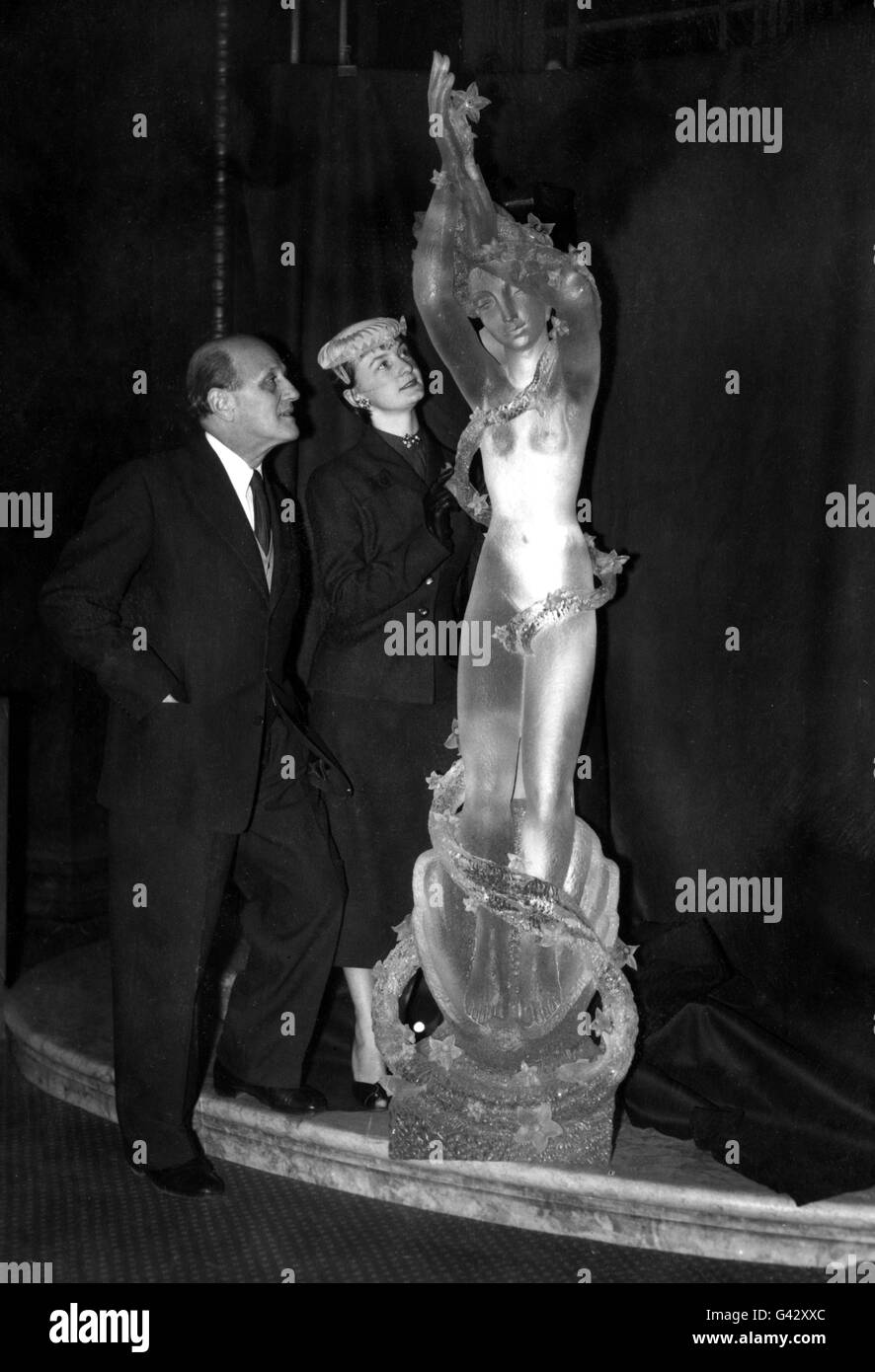 Dr. Arthur Fleischmann ARBS, der in Tschechien geborene australische Bildhauer und seine Kunststudentin Cecile im Australia House, London, mit seinem neuen Werk „The Queen of the Seas“ (Geburt der Aphrodite), einer 7 m langen Figur, die aus einem massiven, halbtonnenschweren Block aus Plexiglas geschnitzt wurde. Es ist das größte Stück Skulptur, das jemals in das neue Material geschnitzt wurde. Die Figur soll in der Embarkation Hall des neuen Pacific Steam Navigation Liners Reina del Mar platziert werden, der jetzt in Harland und Wolff's Werft in Belfast eingebaut wird. Stockfoto