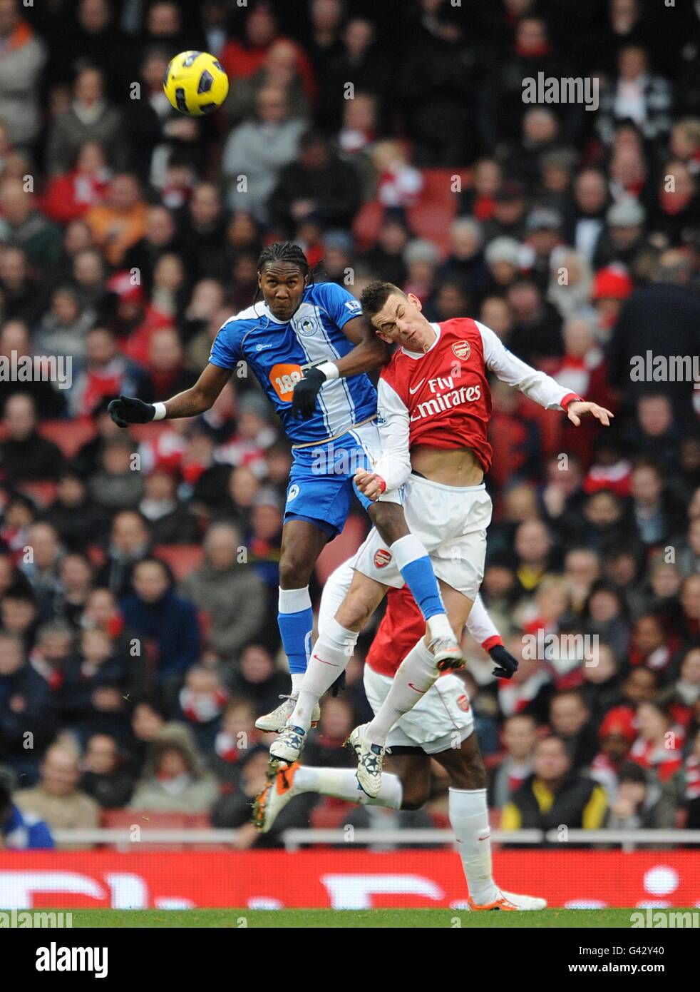 Fußball - Barclays Premier League - Arsenal gegen Wigan Athletic - Emirates Stadium. Laurent Koscielny (rechts) von Arsenal und Hugo Rodallega (letf) von Wigan Athletic kämpfen um den Ball in der Luft Stockfoto Fußball - Barclays Premier League - Arsenal gegen Wigan Athletic - Emirates Stadium. Laurent Koscielny (rechts) von Arsenal und Hugo Rodallega (letf) von Wigan Athletic kämpfen um den Ball in der Luft Stockfoto