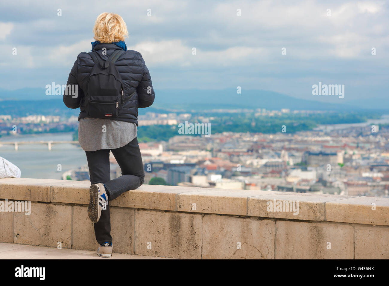 Eine junge weibliche Touristen trägt einen Rucksack Umfragen des Zentrums von Budapest von der Oberseite des Gellért-hegy (Hügel) auf der Budaer Seite der Donau, Ungarn. Stockfoto