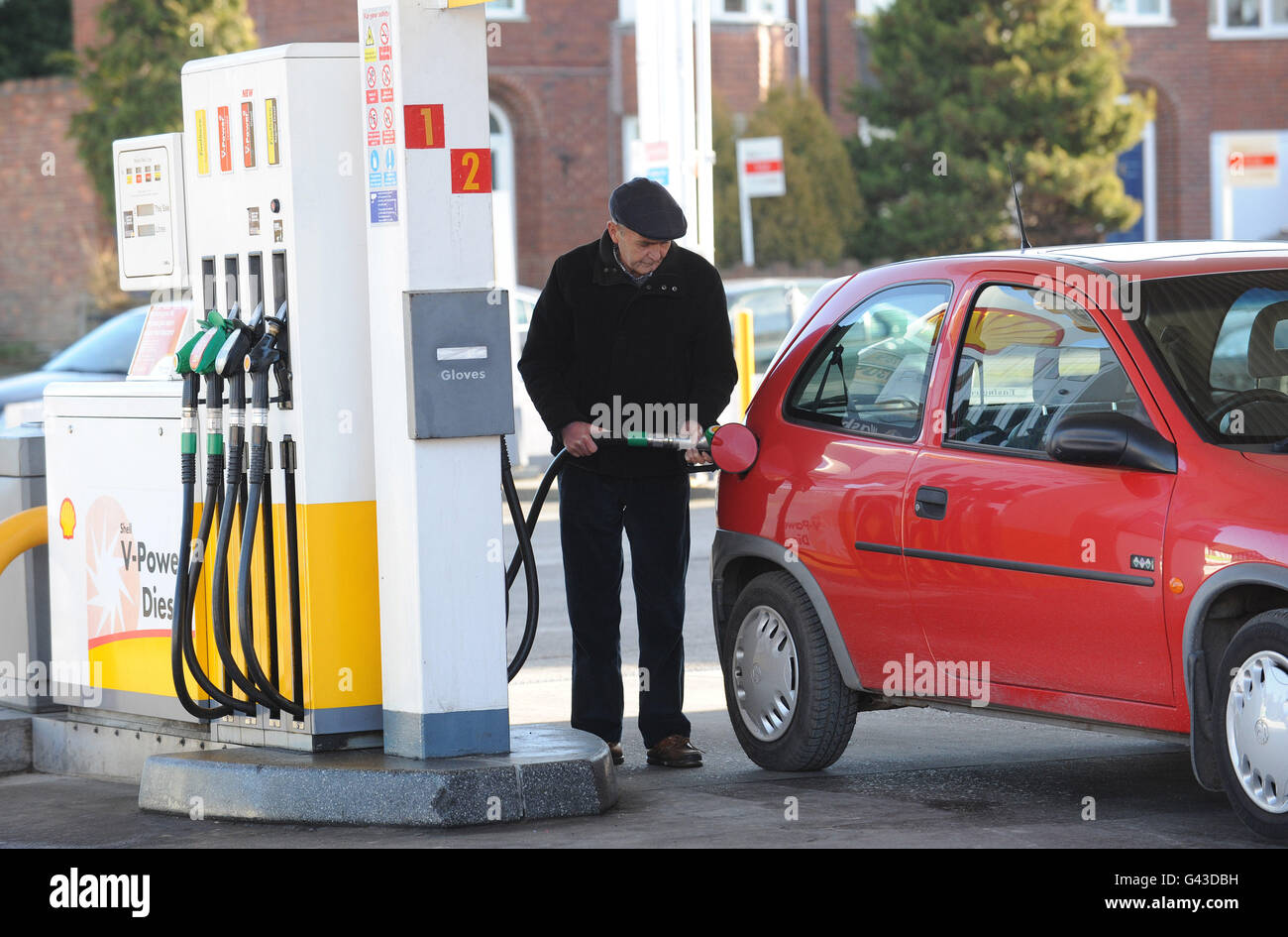 Ein Mann füllt sein Auto mit Kraftstoff bei einem Shell-Tankstelle Stockfoto