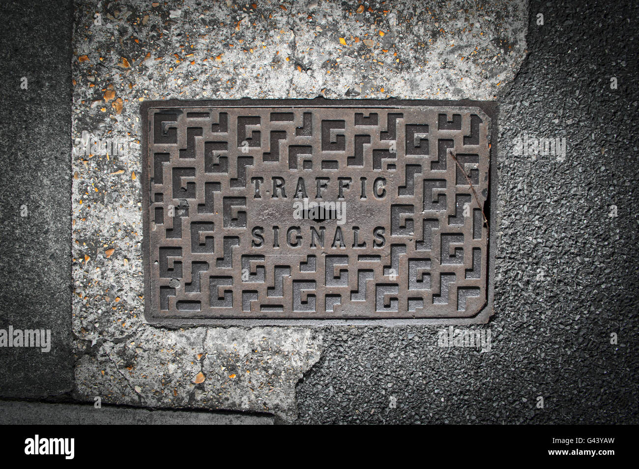 Verkehrszeichen-Einsteigeloch-Abdeckung in den Asphalt und Beton Stockfoto