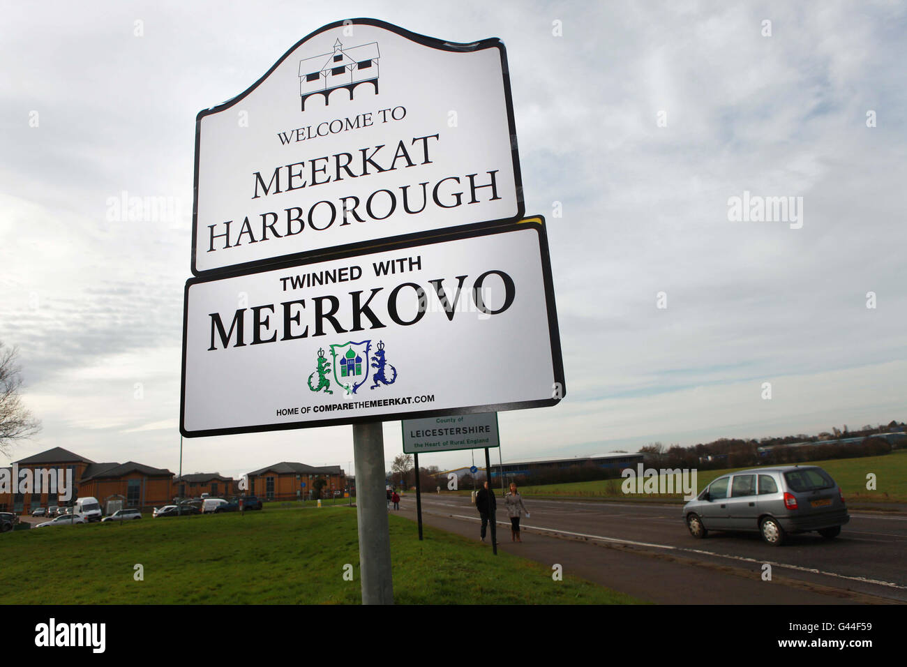 Ein neues Straßenschild nach Market Harborough in Leicestershire wird offiziell Meerkat Harborough für den Tag, da die Stadt die britische Partnerstadt des fiktiven russischen Dorfes Meerkovo, Heimat von Aleksandr Orlov, Gründer von comparethemeerkat.com genannt wird. Stockfoto