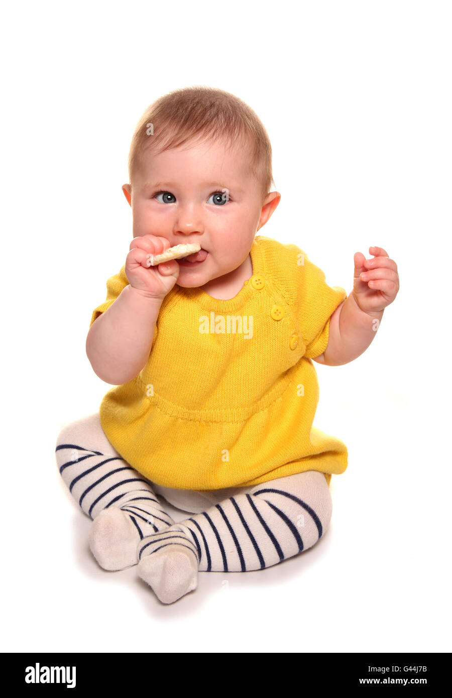 Babymädchen versucht einen Reis-Kuchen-Ausschnitt Stockfoto