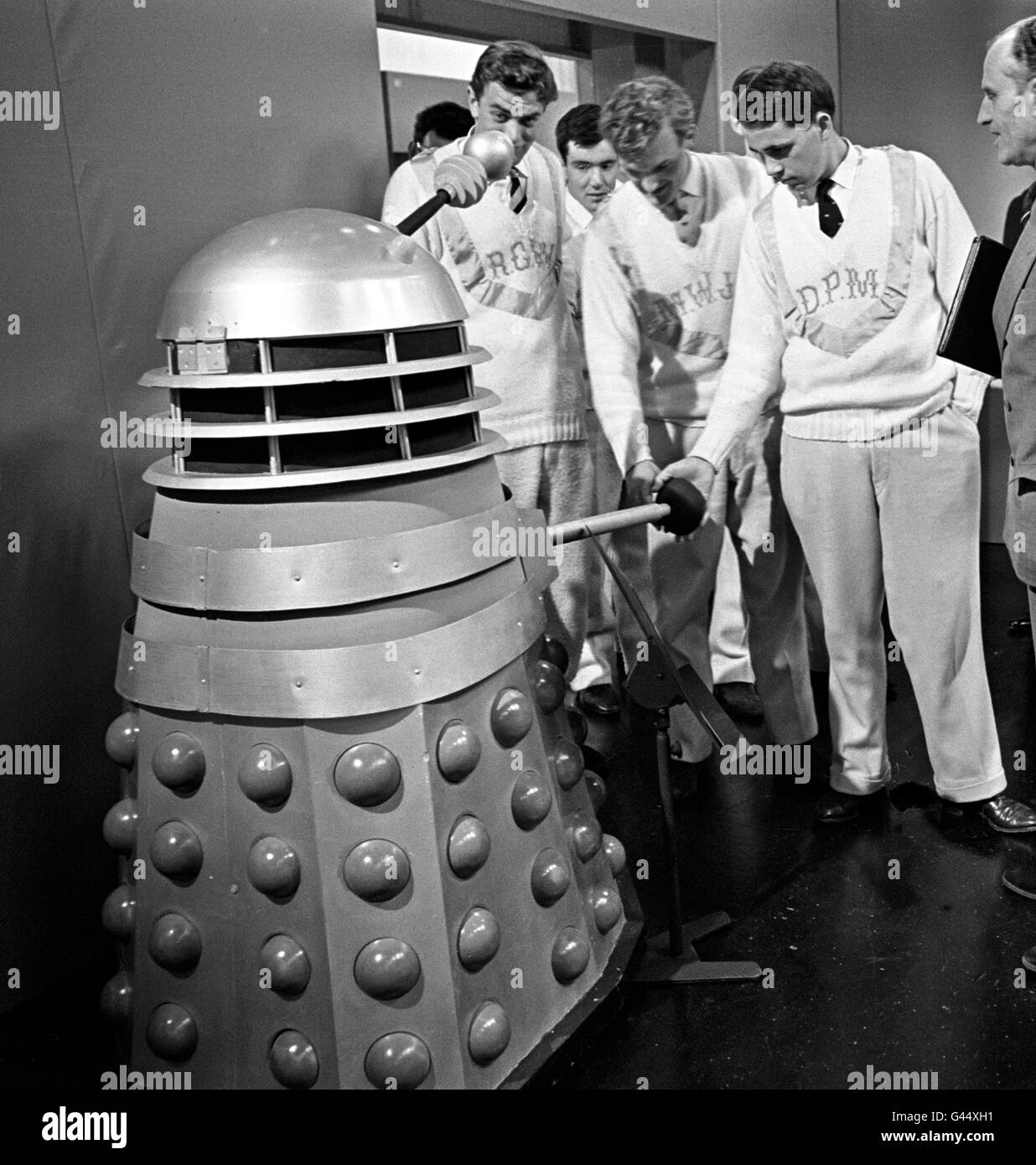 Mitglieder der Cambridge-Crew, weg vom Training, erhalten eine Nahaufnahme eines Dalek, von Dr. Who, während eines Vorabend des Bootrace-Besuchs im BBC-Fernsehzentrum, Shepherd's Bush Stockfoto