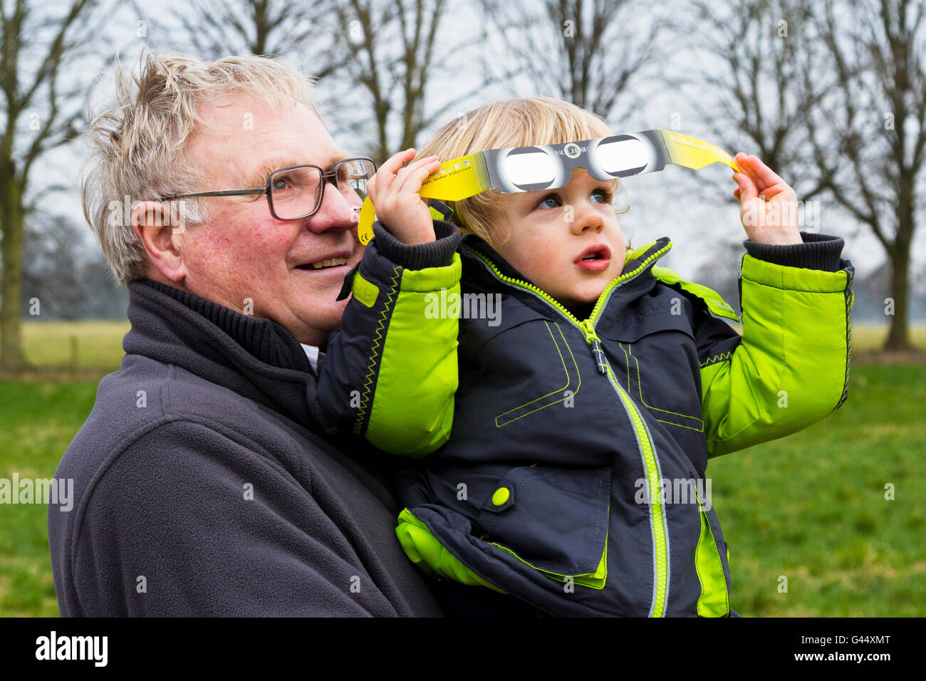 Großvater seinem Enkel halten, während die partielle Sonnenfinsternis (Derbyshire, 20. März 2015, UK) Stockfoto