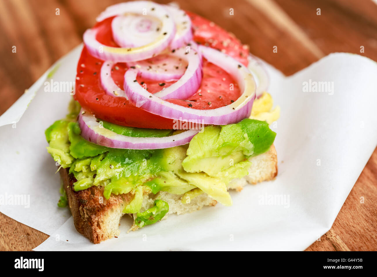 Avocado-Toast mit Tomaten und roten Zwiebeln Stockfoto