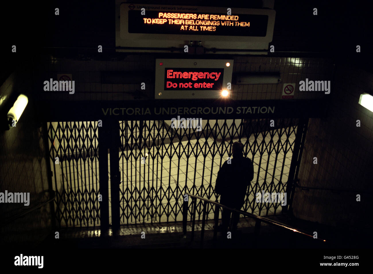Eine Einzelperson steht vor den verschlossenen Toren der Victoria Underground Station in London, nachdem ein systemweiter Stromausstieg dazu führte, dass Tausende von Passagieren in U-Bahn-Zügen gestrandet waren. London Underground plante eine Notfallregeneration des Systems, damit alle Züge Bahnhöfe erreichen. Stockfoto