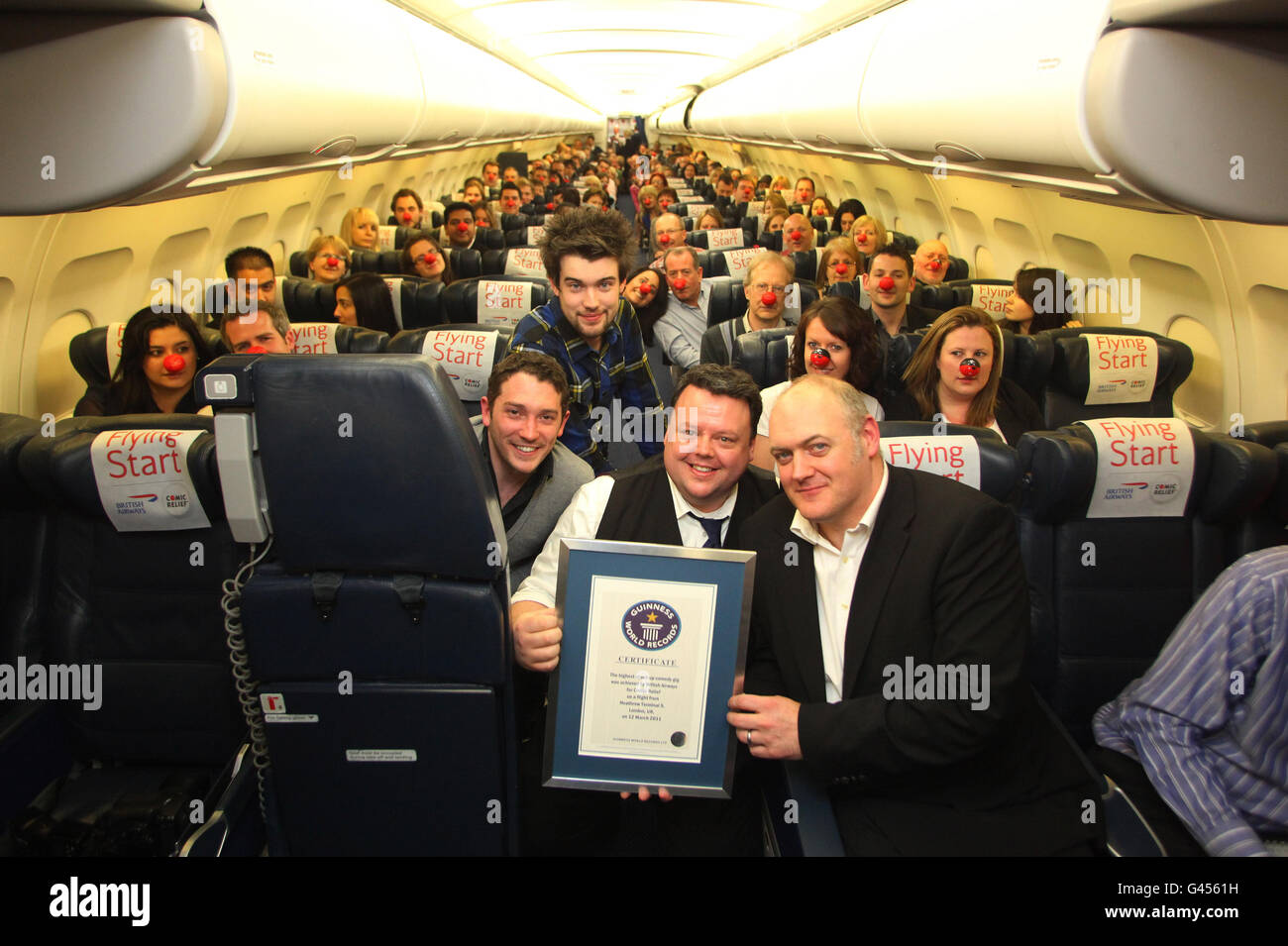 Craig Glenday aus Guinness (Mitte) überreicht das Zertifikat an die Comedians Dara O'Briain (rechts), Jack Whitehall und Jon Richardson (links), nachdem sie einen neuen Guinness-Weltrekord-Titel für den „höchsten Stand-up-Comedy-Gig der Welt“ zur Unterstützung des Red Nose Day an Bord eines dedizierten British Airways A321-Flugzeugs aus London Heathrow aufgestellt hatten. Stockfoto