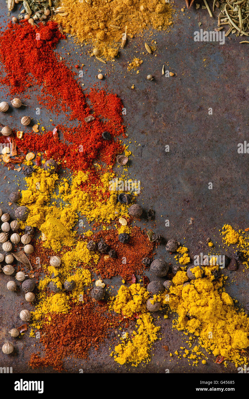 Würzigen Hintergrund mit Sortiment von verschiedenen hot Chili und Piment Paprika und Mischung aus anderen Gewürzen über altes rostiges Eisen Hinterg Stockfoto