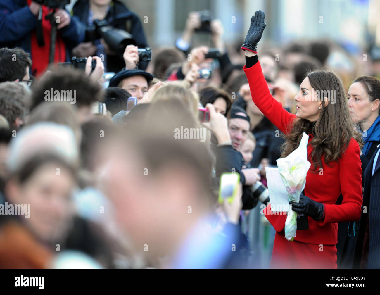 Die Verlobte von Prinz William Kate Middleton winkt bei einem Besuch in St. Andrews in Schottland, wo sie und Prinz William sich zum ersten Mal trafen, zu den Publikumsbesuchern. Stockfoto