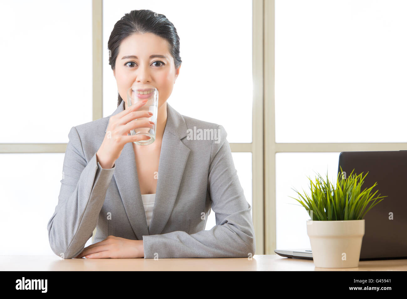 Junge asiatische Geschäftsfrau Trinkglas Wasser im Büro Stockfoto