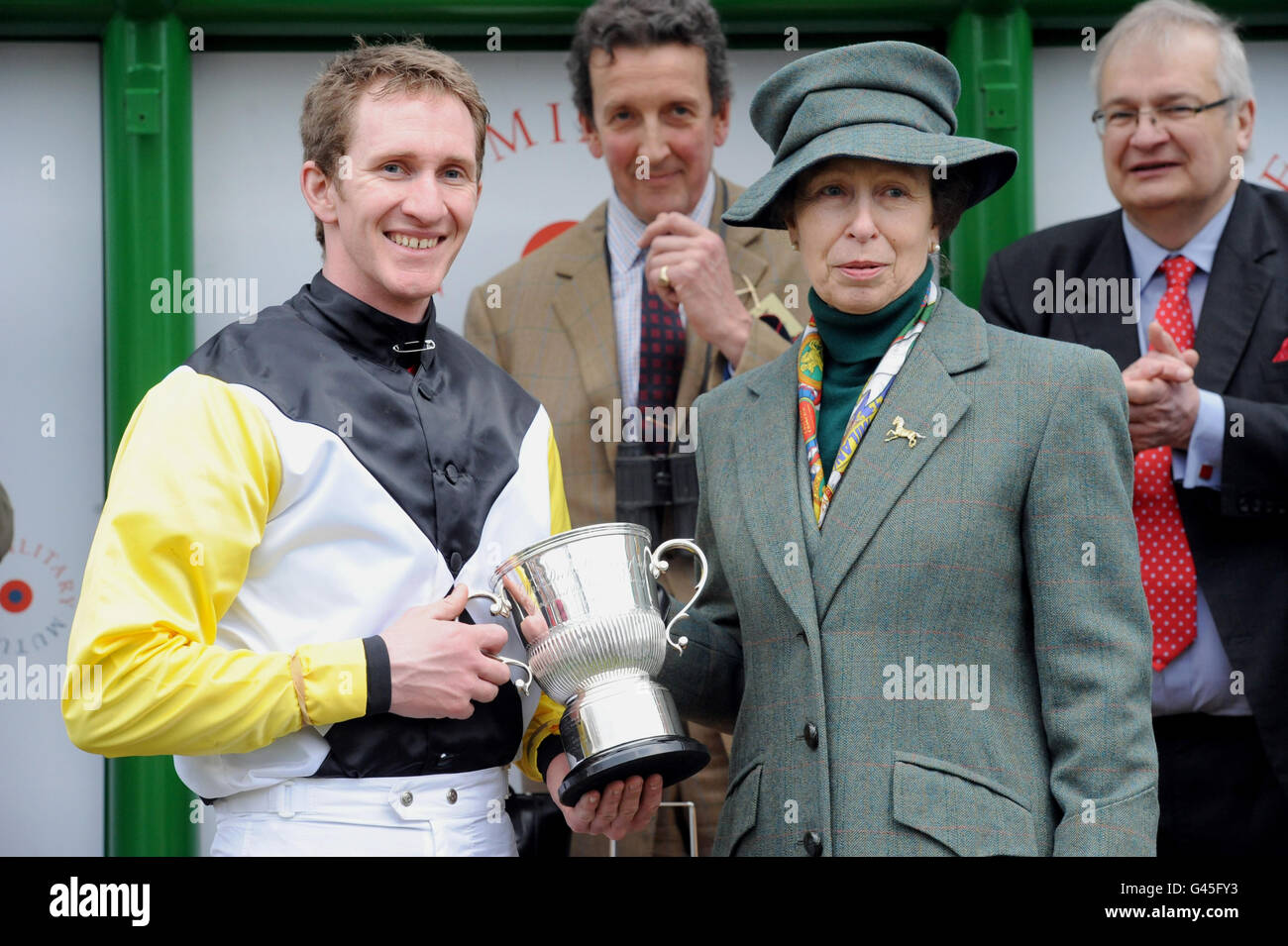 Jody Sole wird mit dem Gold Cup von Prinzessin Anne nach dem Gewinn des Grand Military Gold Cup (Chase for Amateur Riders) auf Blue Teen während des Grand Military Gold Cup Day auf Sandown Racecourse, Surrey, überreicht. Stockfoto