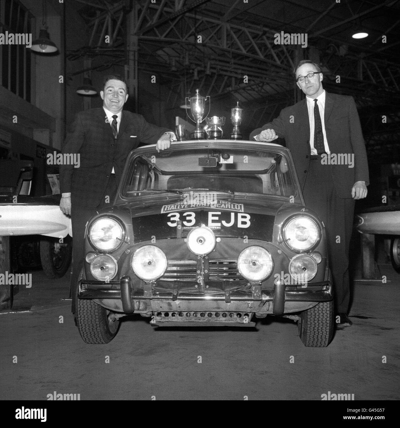 Paddy Hopkirk (l.) und sein Beifahrer Henry Liddon mit dem Mini Cooper S, dem Auto, das sie 1964 bei der Rallye Monte Carlo zum Sieg fuhren. Mini feierte sein 30-jähriges Jubiläum und führte vor dem Start der Rallye Monte Carlo mit dem von BMW und Rover entworfenen ACV 30 eine Paraderunde an. Stockfoto