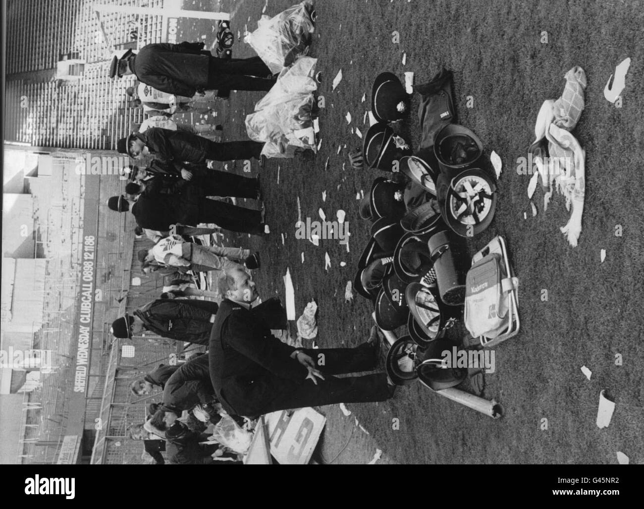 Bibliotheksdatei 231669-32 vom 11.4.90: Ein Polizist sucht unter anderem nach seinem Helm, der von der Polizei weggeworfen wurde, als er Fans bei der Hillsborough-Katastrophe half. Heute (Donnerstag) sollten Monate der Unsicherheit enden, da mehr als 20 Polizisten eine Entschädigung für die psychologischen Verletzungen forderten, die sie erlitten haben, nachdem sie den Opfern der Tragödie von 1989 geholfen hatten. Der Appell wird von Verwandten der 96 Fans, die in Hillsborough starben, genau beobachtet, von denen einige Stressschäden abgelehnt wurden, während andere nur bescheidene Summen erhielten. Siehe PA Story COURTS Hillborough. Foto von PA-Ende Stockfoto