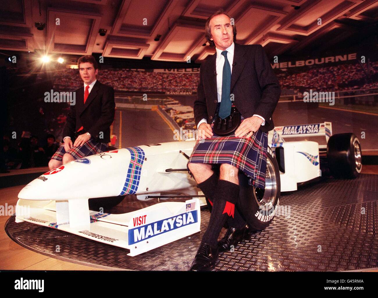 Der dreimalige ehemalige Formel-1-Weltmeister Jackie Stewart sitzt rechts mit seinem Sohn Paul Stewart (Geschäftsführer des Teams) auf ihrem neuen Stewart-Ford SF-1, der in London auf den Markt kam. * das Fahrzeug mit dem Markenzeichen Stewart Tartan wurde in nur neun Monaten entwickelt und gebaut und wird im März nächsten Jahres beim Grand Prix von Melbourne für das neue Team an den Start gehen. 15/6/01: Stewart hat eine Ritterschaft in der Queen's Birthday Honors Liste verliehen worden. Stockfoto