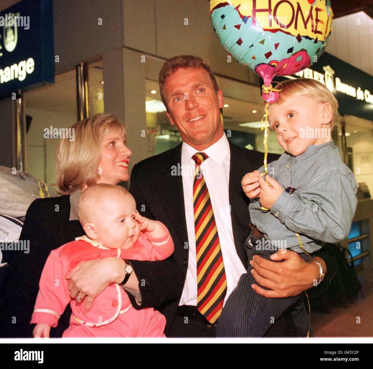 Alec Stewart wird von seiner Frau Lynn und seinen Kindern Emily (links, 6 Monate) und Andrew am Flughafen Heathrow begrüßt, nachdem er von der England Cricket Tour durch Neuseeland zurückgekehrt ist. Stockfoto