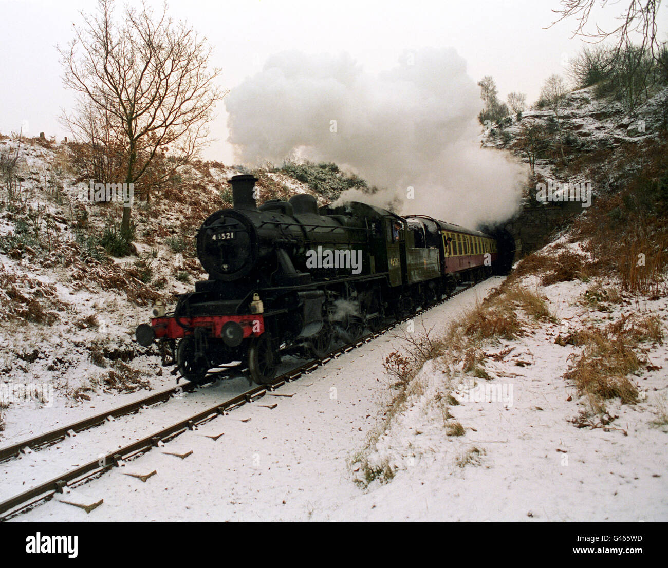Der LMS-Entwurf 2-6-0 der Severn Valley Railway verlässt den Bewdley-Tunnel. Die bereits malerische Strecke wurde nach einem nächtlichen Sturz zusätzlich von Schnee angezogen. Die in den 50er Jahren gebaute Lokomotive wurde auf Zweigs- und Landstraßen eingesetzt, spielte aber in jüngerer Zeit eine Hauptrolle in der Comedy-Serie "Oh Doctor Beeching", die in der nahe gelegenen Arley gedreht wurde und für die sie wieder "Blossom" getauft wurde. Stockfoto