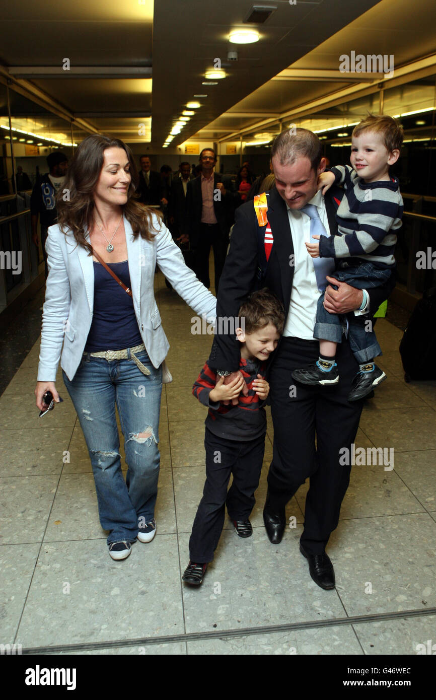 Cricket - Ankunft Des England-Teams - Flughafen Heathrow. Der Engländer Andrew Strauss wird von seiner Frau Ruth und den Söhnen Luca (getragen) und Sam bei seiner Ankunft am Londoner Flughafen Heathrow empfangen. Stockfoto