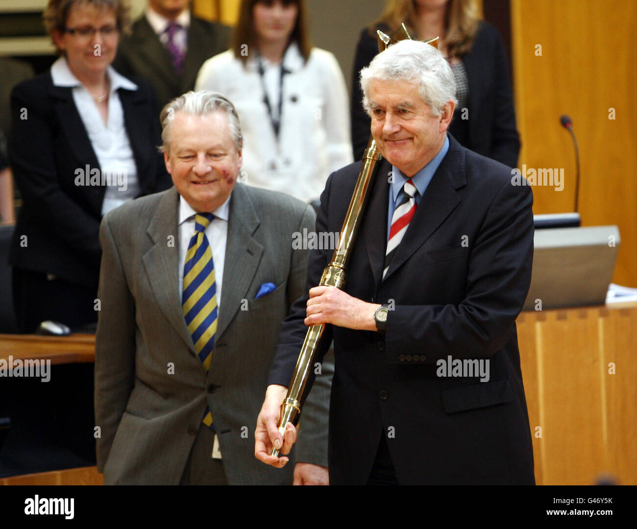 Rhodri Morgan, ehemaliger erster Minister, begleitet von dem Präsidialbeamten Dafydd Ellis-Thomas (links), trägt die zeremonielle Keule des Senedd, der heute aus dem öffentlichen Leben ausscheiden wird. Stockfoto