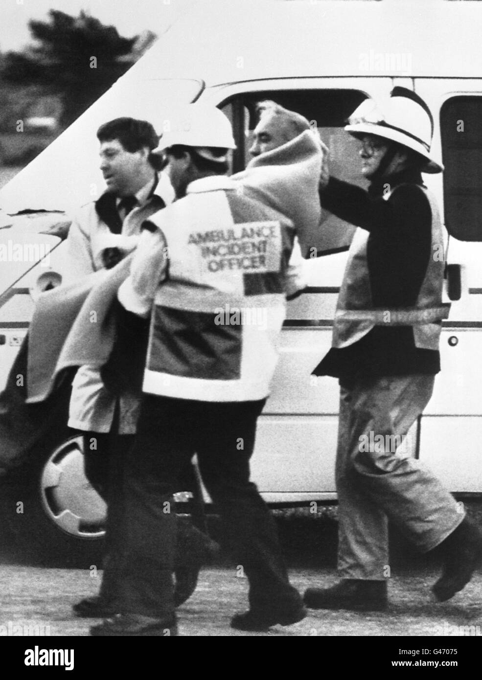 Ein Überlebender mit einer Decke bekleidet, der von Krankenwagen bei seiner Ankunft in Aberdeen nach der Explosionskatastrophe an Bord der Nordseeölproduktionsplattform Piper Alpha getragen wurde. Stockfoto