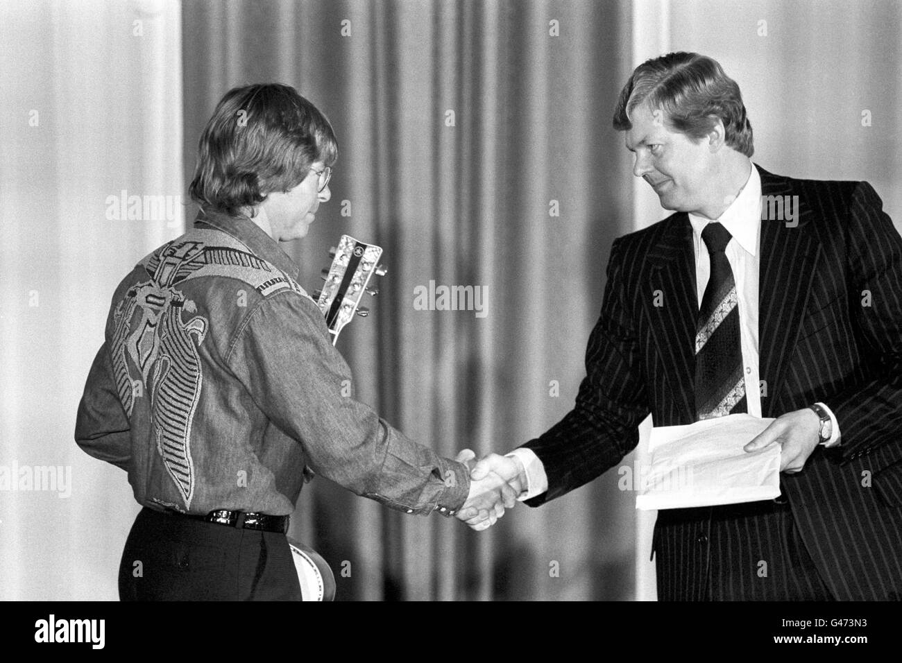 Der amerikanische Sänger John Denver, links, gab ein Lied über Wale ab und überreichte dem Vorsitzenden der Internationalen Walfangkommission, Herrn T Asgeirsson aus Island, eine Petition, als die 31. Jahrestagung der kommission im Café Royal, London, eröffnet wurde. Stockfoto