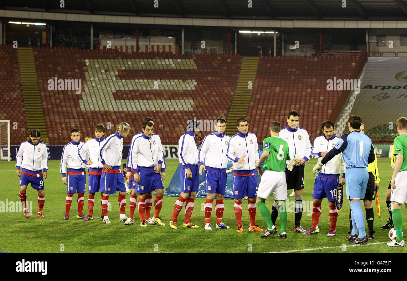 Die Spieler aus Serbien und Nordirland schütteln sich vor dem Anpfiff die Hände Vor leeren Sitzen im Red Star Stadium Stockfoto